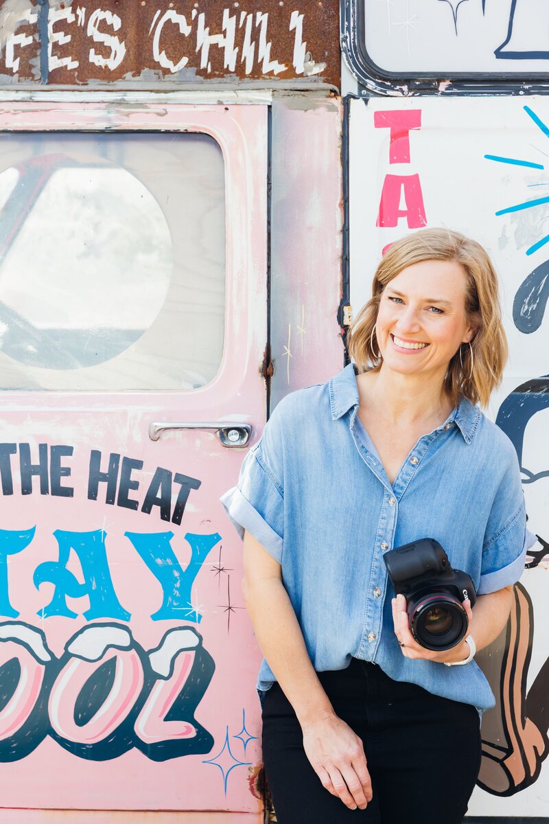 Fi Mims is standing and  holding a professional camera in Melbourne