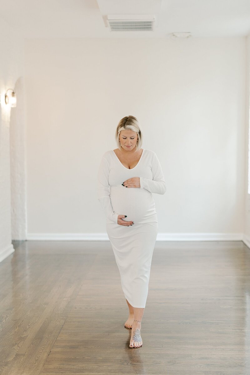 Pregnant woman in white dress in studio by Maternity Photographer Richmond VA