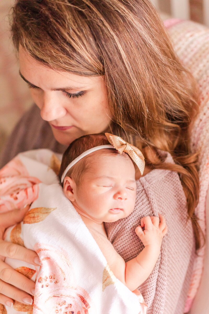 Mom and newborn daughter snuggling