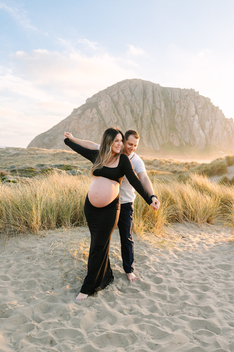 expecting mom and dad being playful on the beach