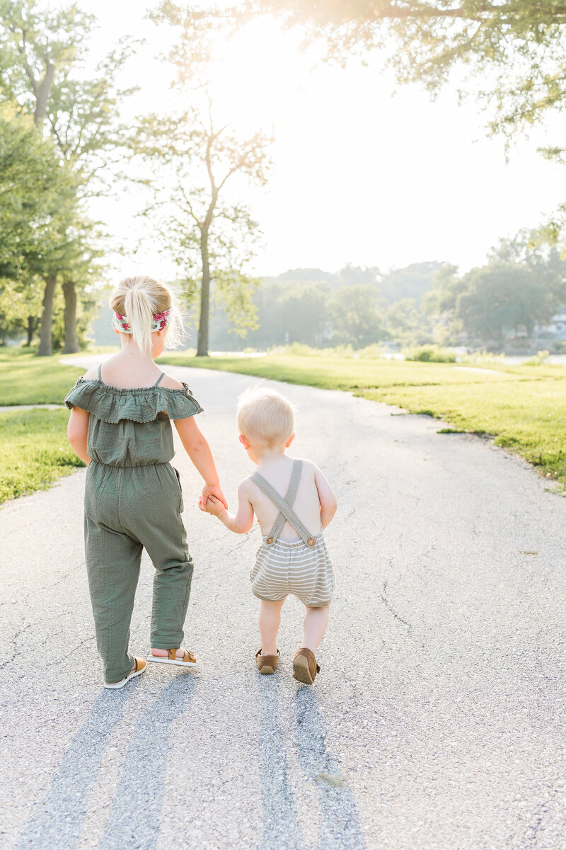 two kids walking while holding hands