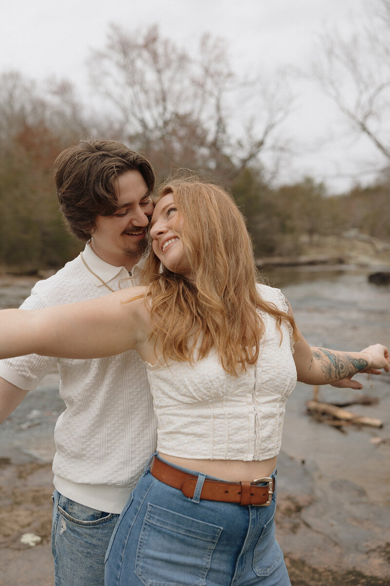 couple by the river at the mill at fine creek during their engagement session