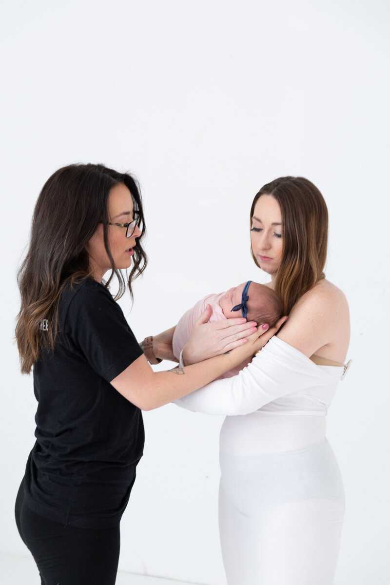 Photographer with new mom posed in white