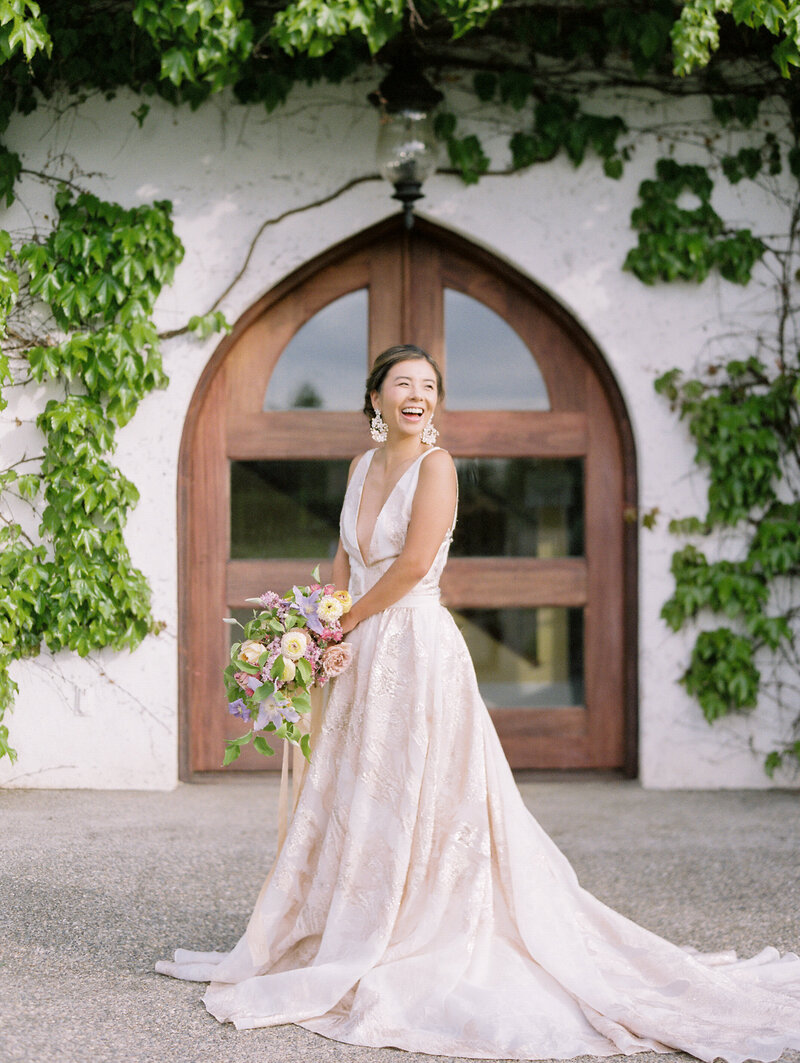 bride laughing and looking into the distance at Monet Vineyards