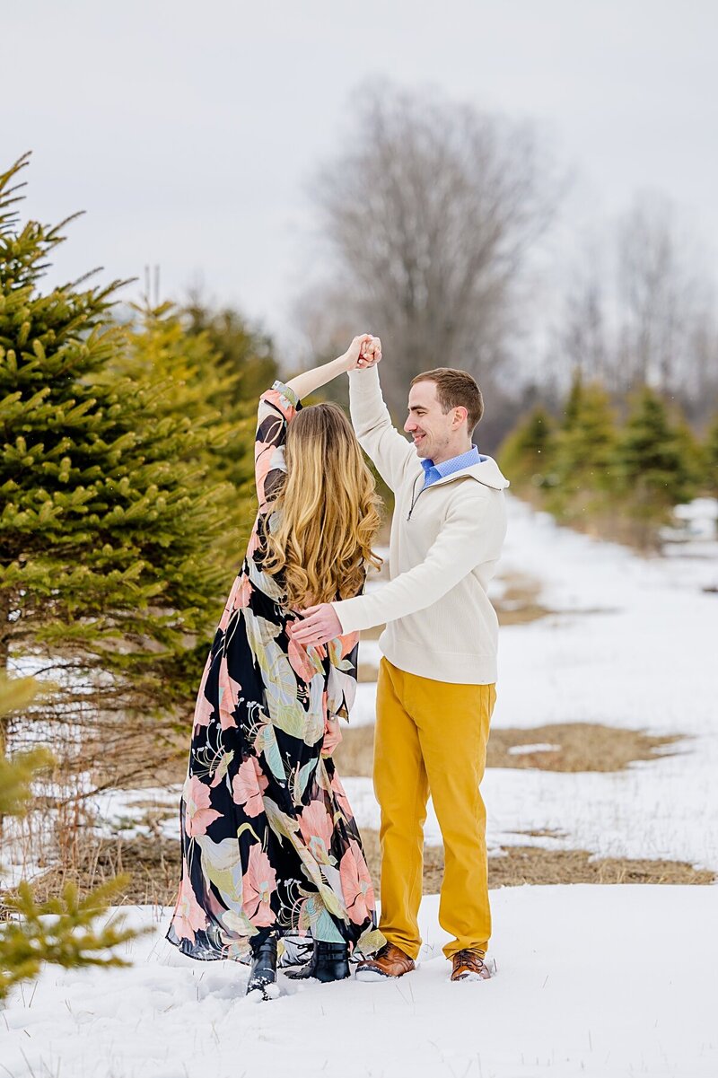 guy-spinning-girl-in-tree-farm-winter