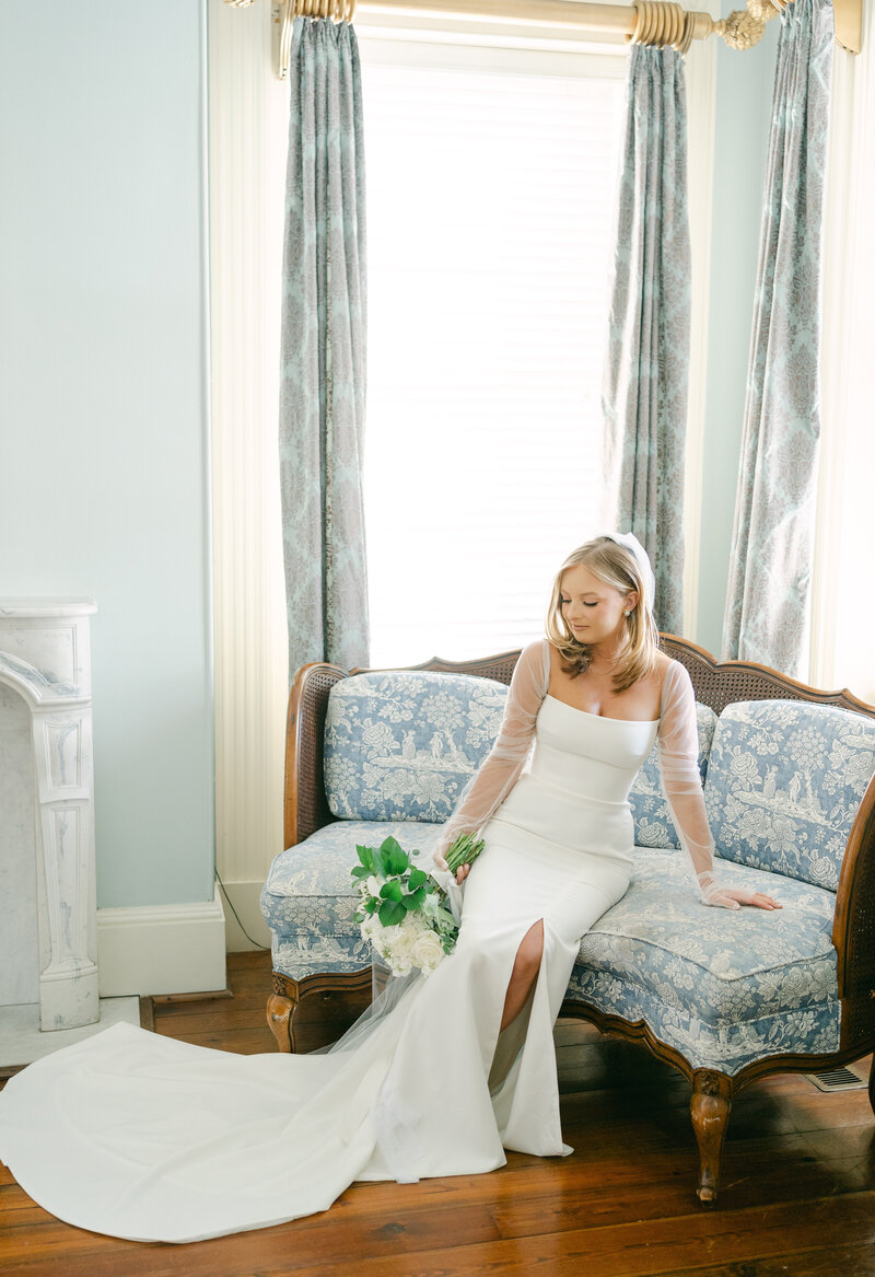classy bride on vintage couch on wedding day
