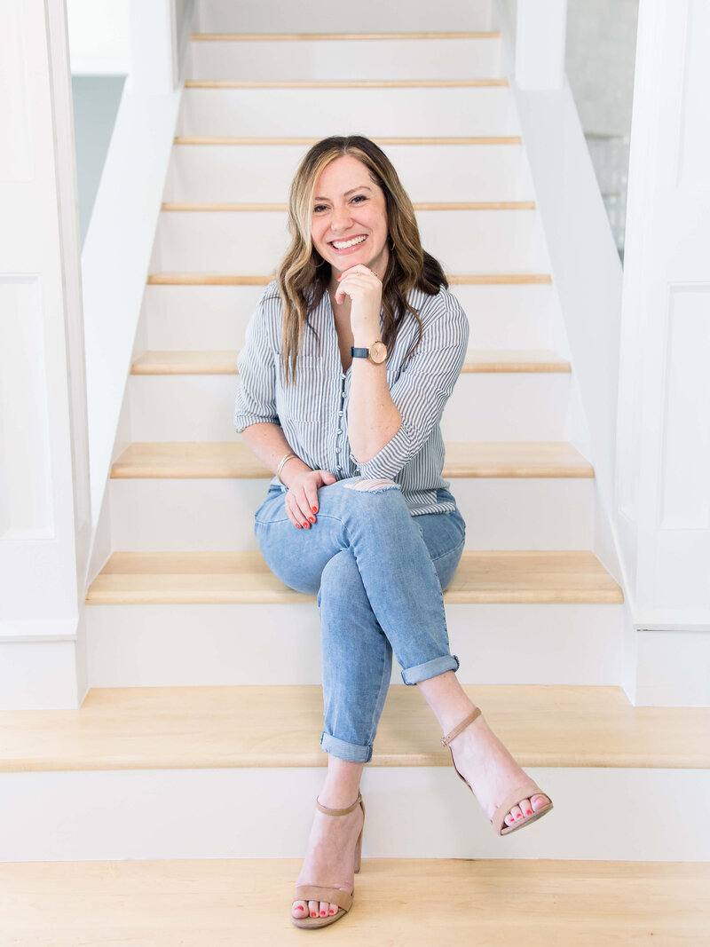 woman sitting on staircase with legs crossed and smiling