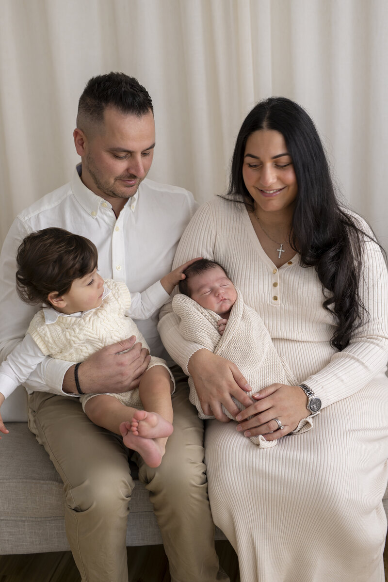 Studio family photoshoot Melbourne with parents embracing children in natural light