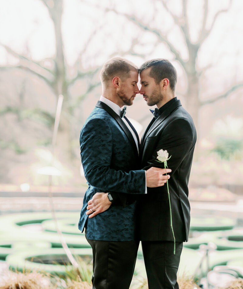 Gay couple standing forehead to forehead, sharing a quiet and intimate moment. A heartfelt connection captured in a timeless, romantic embrace.