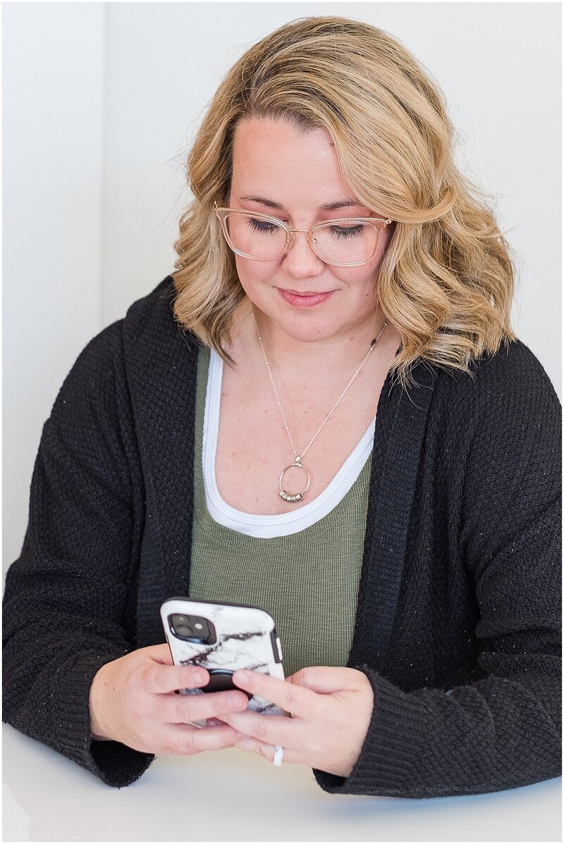 Woman scrolling through phone looking for photos