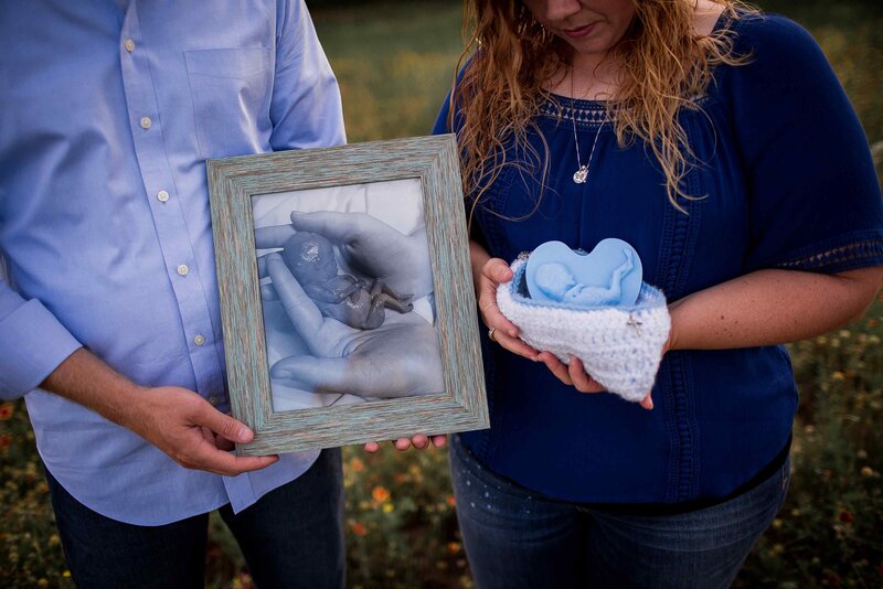 bereaved couple holds knit crochet cradle in memory of stillborn baby boy in Heaven