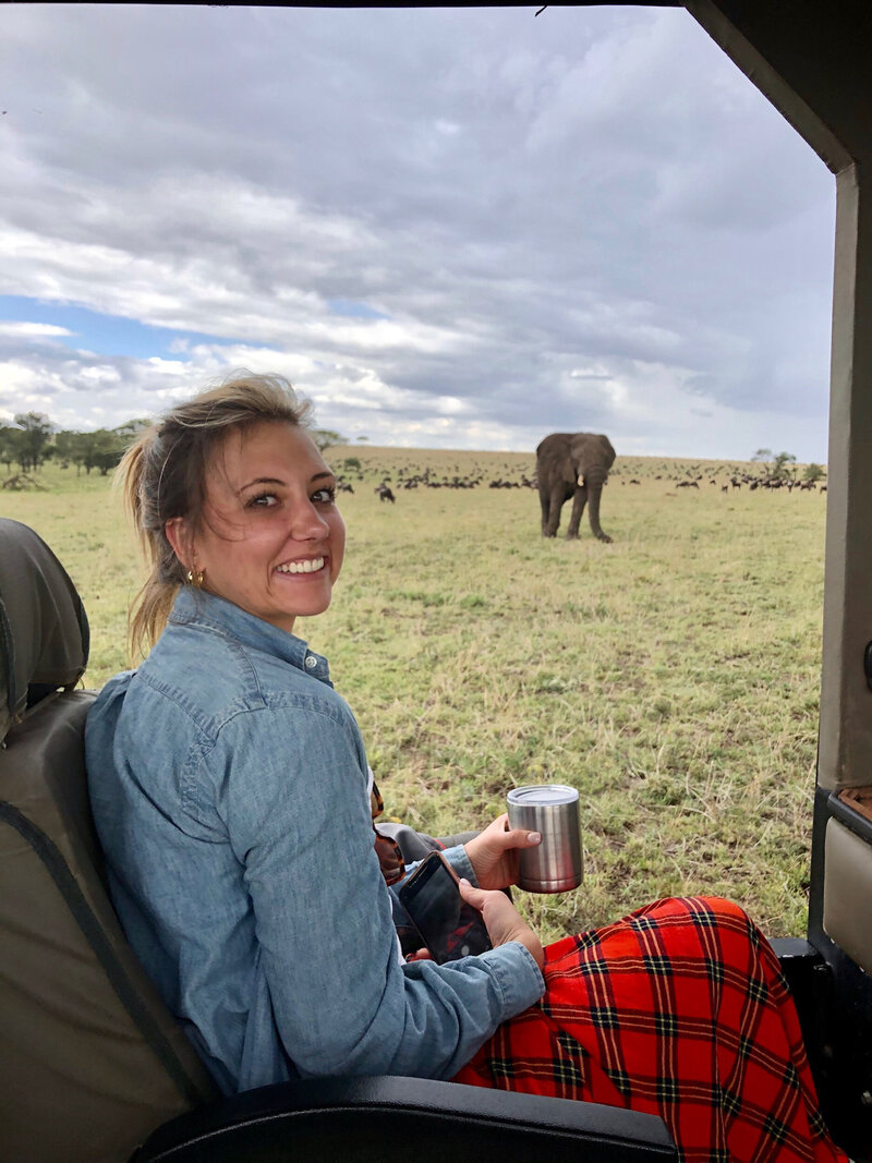 Laine Langenbrunner  smiling on safari with elephants in background