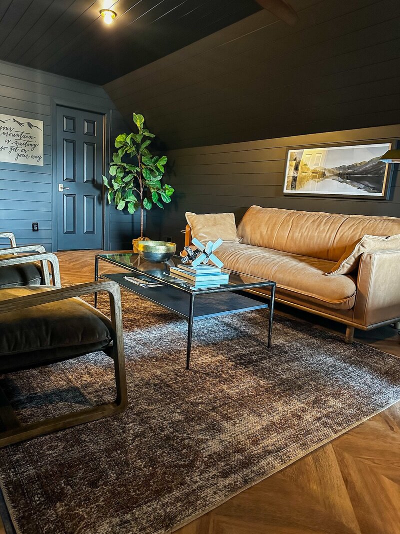 Dark and moddy office space with dark grey walls and a textured rug.