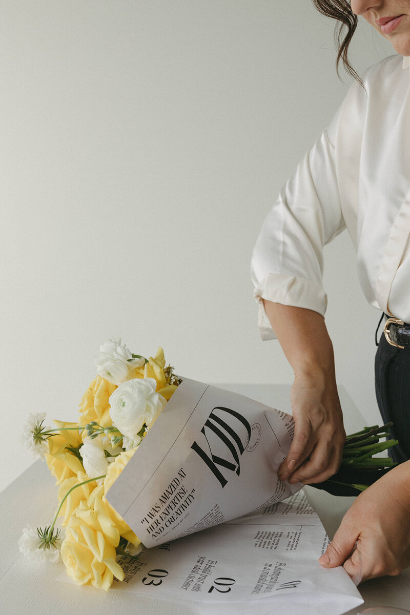 girl wrapped a bouquet in branded paper