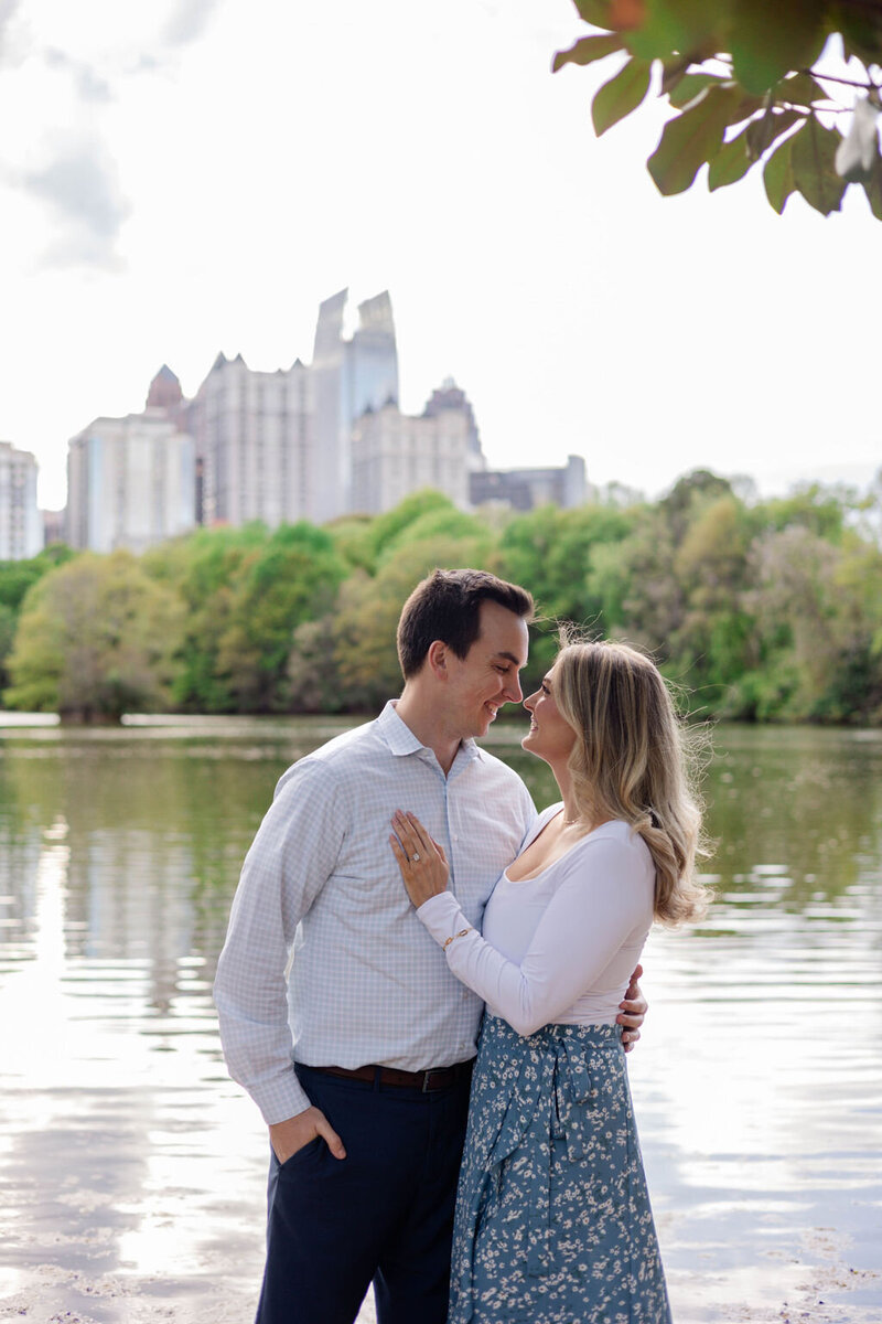 couple embracing atlanta skyline engagement photos