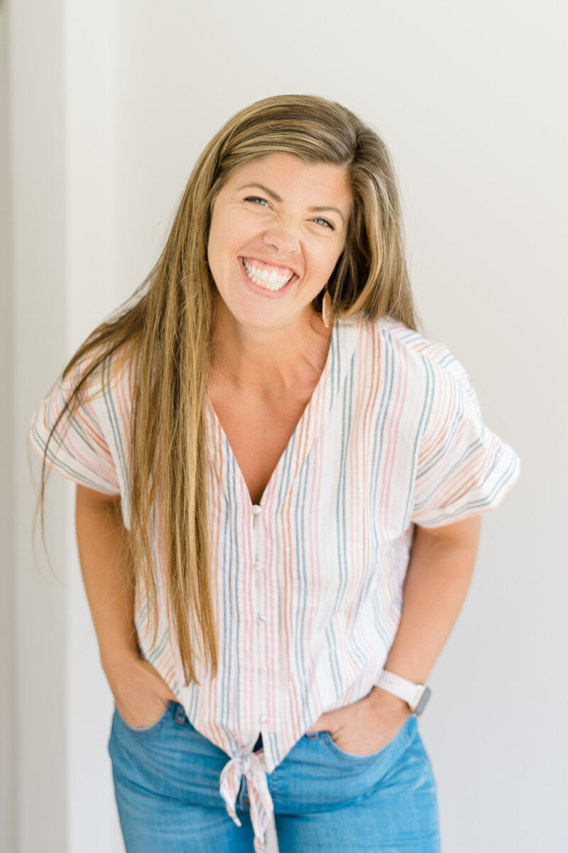 Woman in pastel striped top smiles at camera