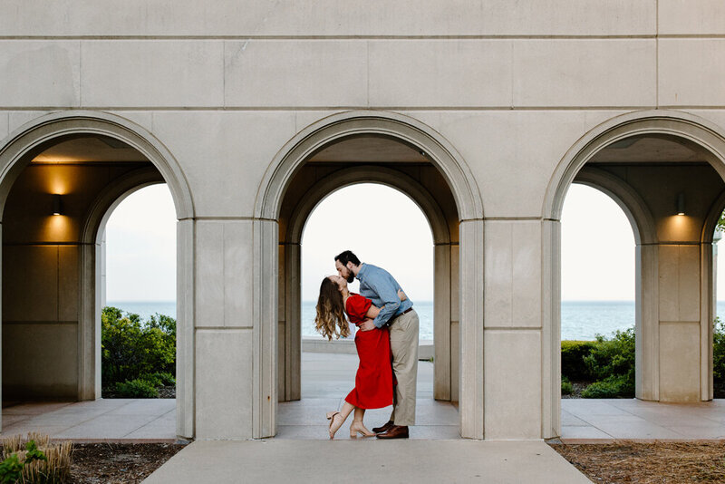 couple kissing in underneath arched buildings