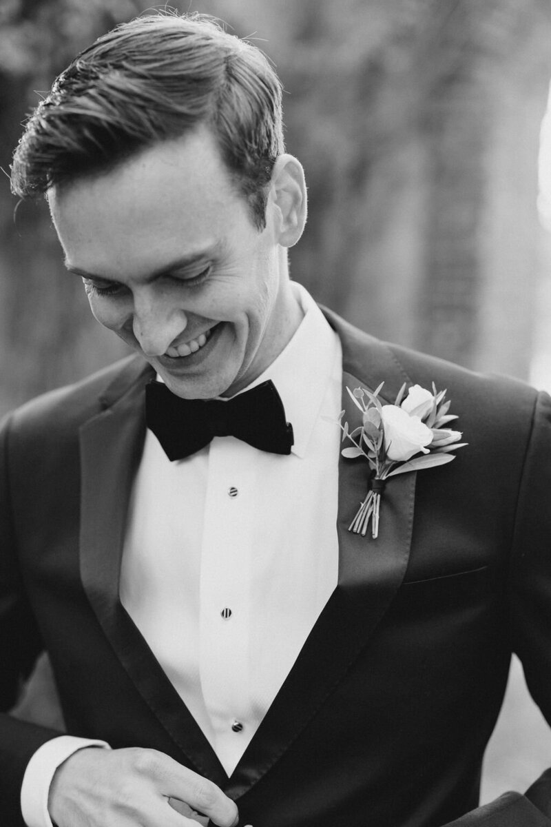 Groom in black tie smiles