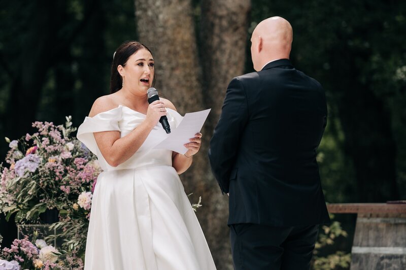 a bride reads vows to groom during wedding ceremony outside at bangor farm