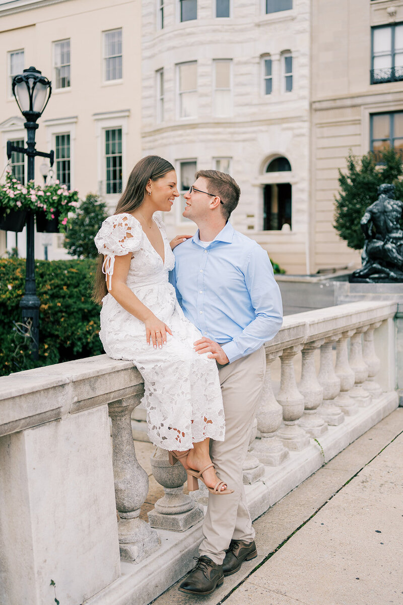 Man and Austin bride to be posing on a stone walkway for engagement photos by Austin wedding photographer