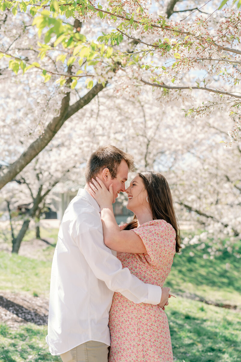 Richmond Photographer - Caitlin Wilcox | a couple in pink floral dress and white shirt share a hug amongst the spring blossoms of Belle Isle in Richmond, VA. 