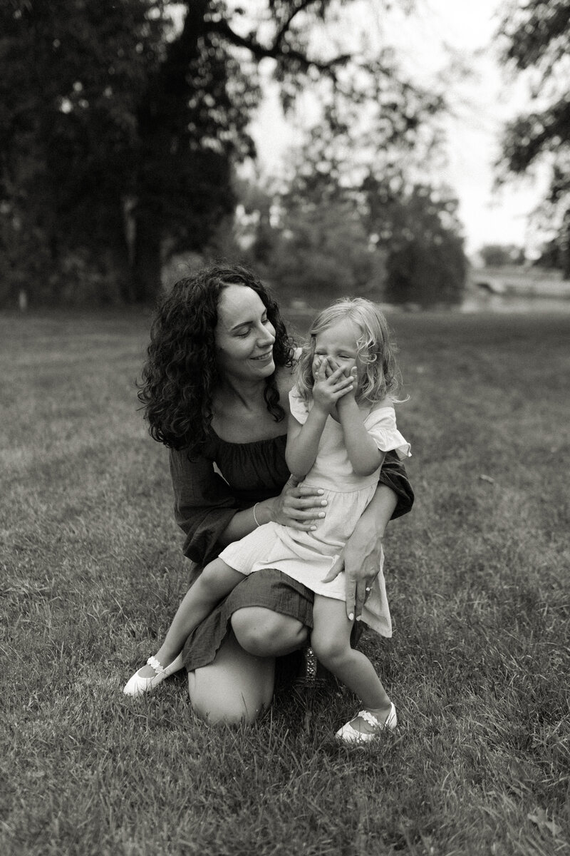 A mom and her daughter giggle together during Summer family photos in Duluth, Minnesota.