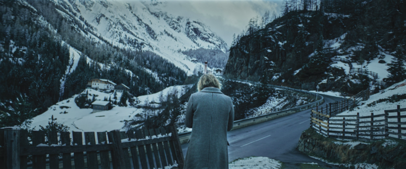 A night-time exterior with contrasting lights and shadows, showcasing noir-inspired cinematography.