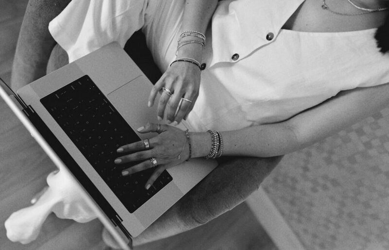 young woman entrepreneur dressed in brown suit types on laptop