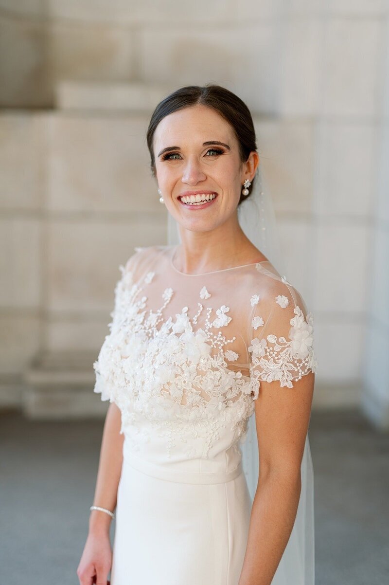 beaming bride in lace top wedding gown smiling for minneapolis wedding photograph