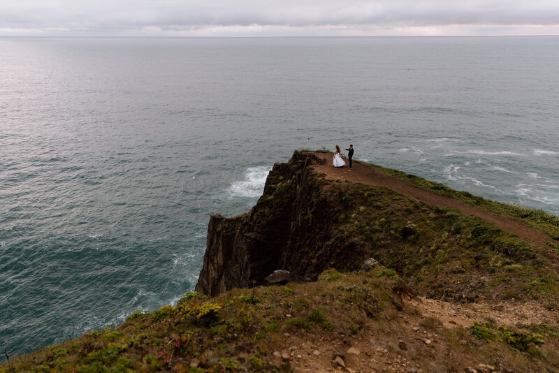 Bride and groom sitting on a bench in the Akron Art Museum with a gallery of paintings behind them. 