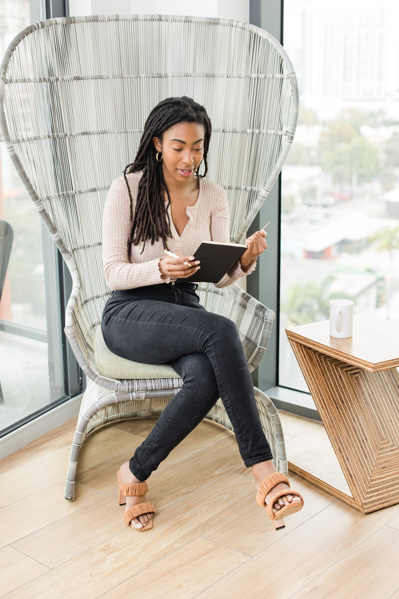 Woman sitting writing on a note pad