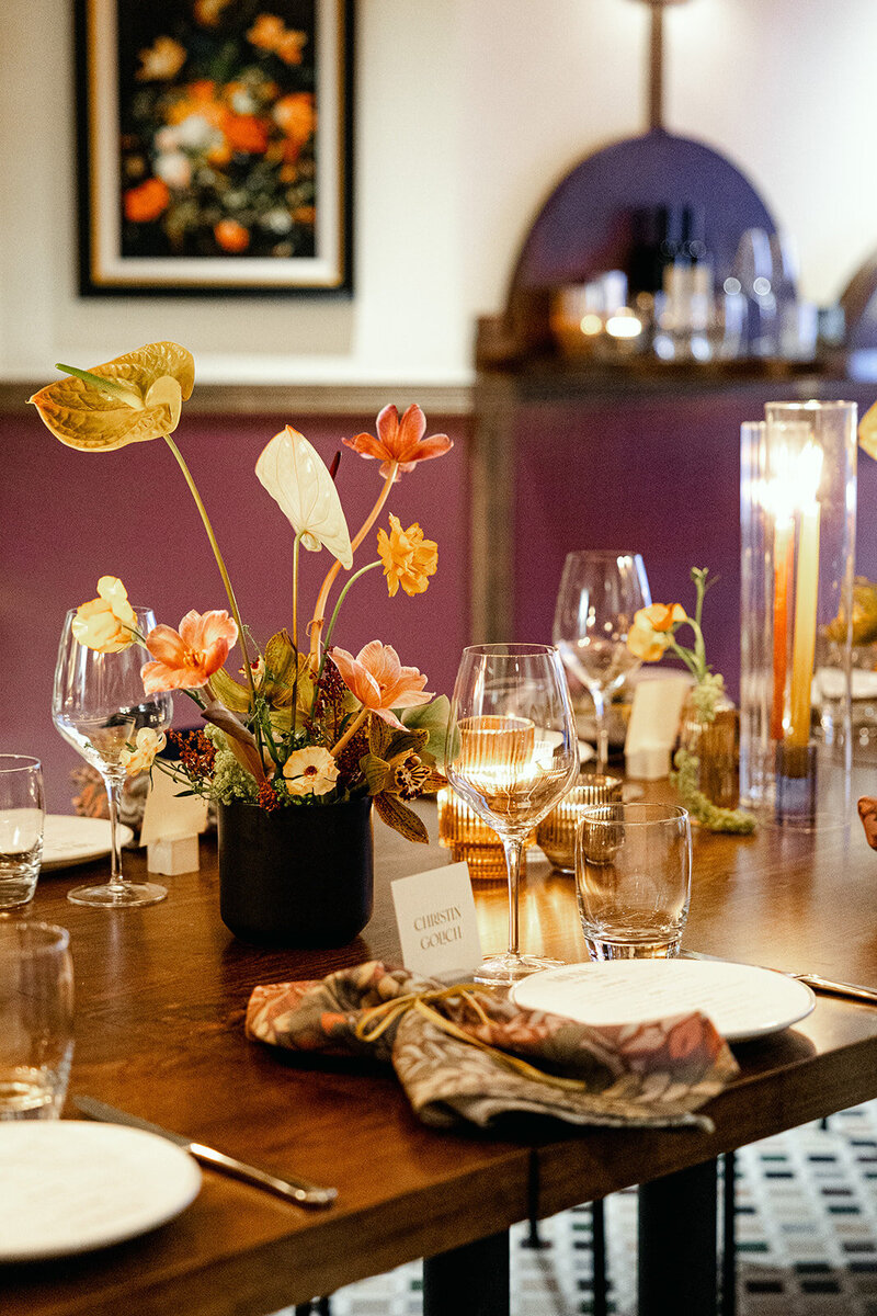 Close-up of an elegantly set wedding table with floral arrangements, candlelit ambiance, and fine dining details.