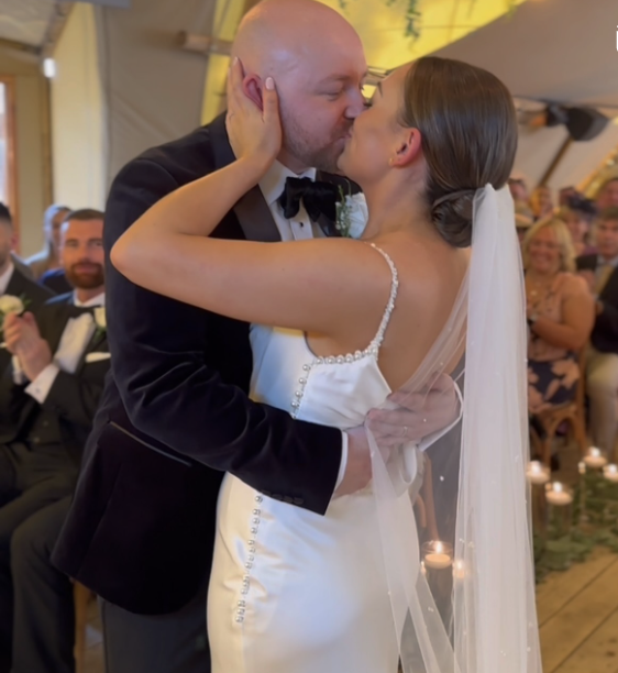 Father of the bride and bride naturally smiling at eachother
