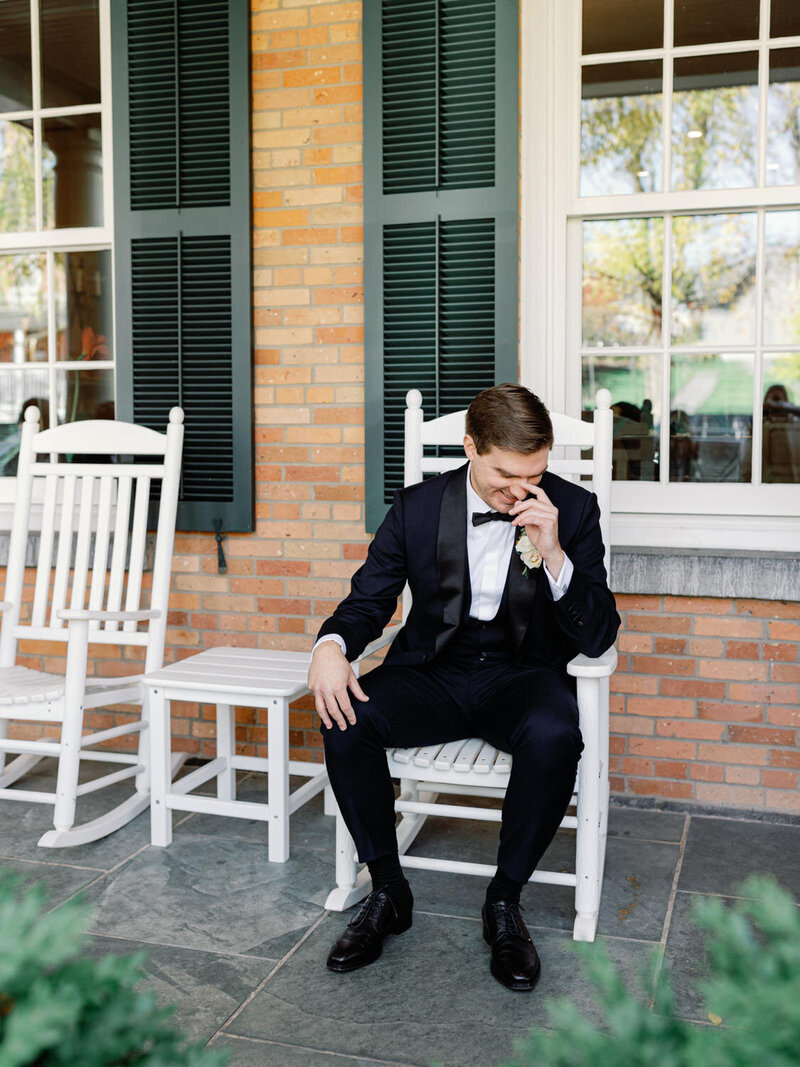 Groom laughs to him self on the Inns of Aurora porch.
