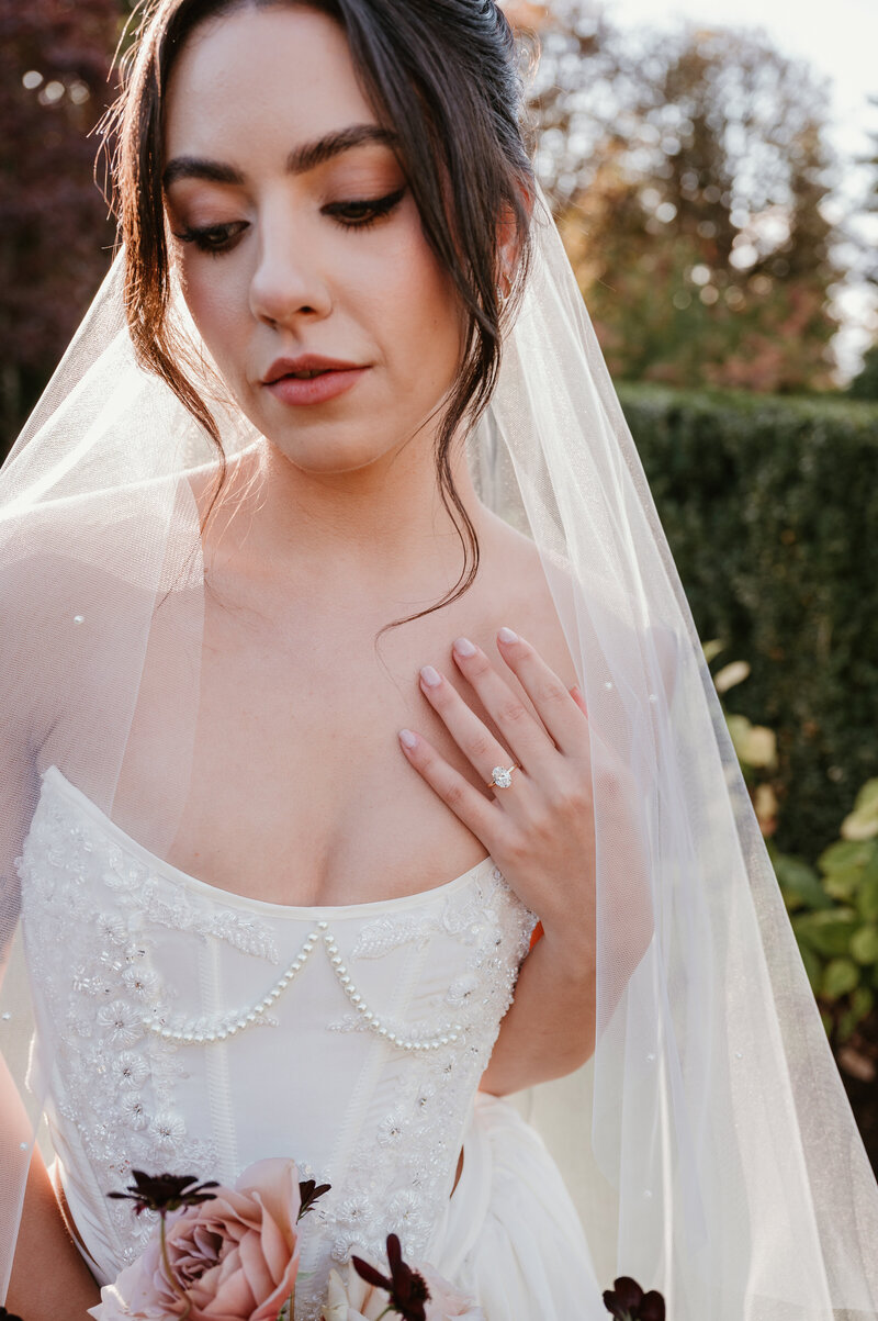 Bride in veil showing engagement ring