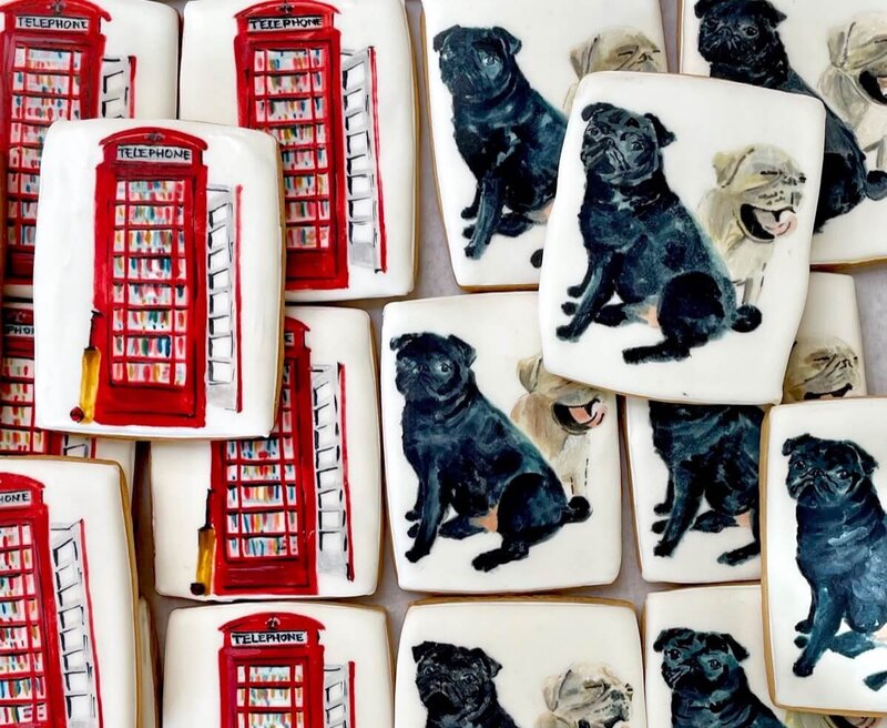 Hand painted biscuits showing two designs (1 of a red telephone box and 1 of 2 dogs)