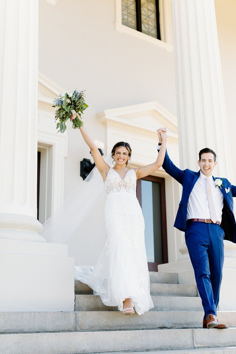 Bride and Groom walking out of grace church in downtown Greenville raising hands and cheering