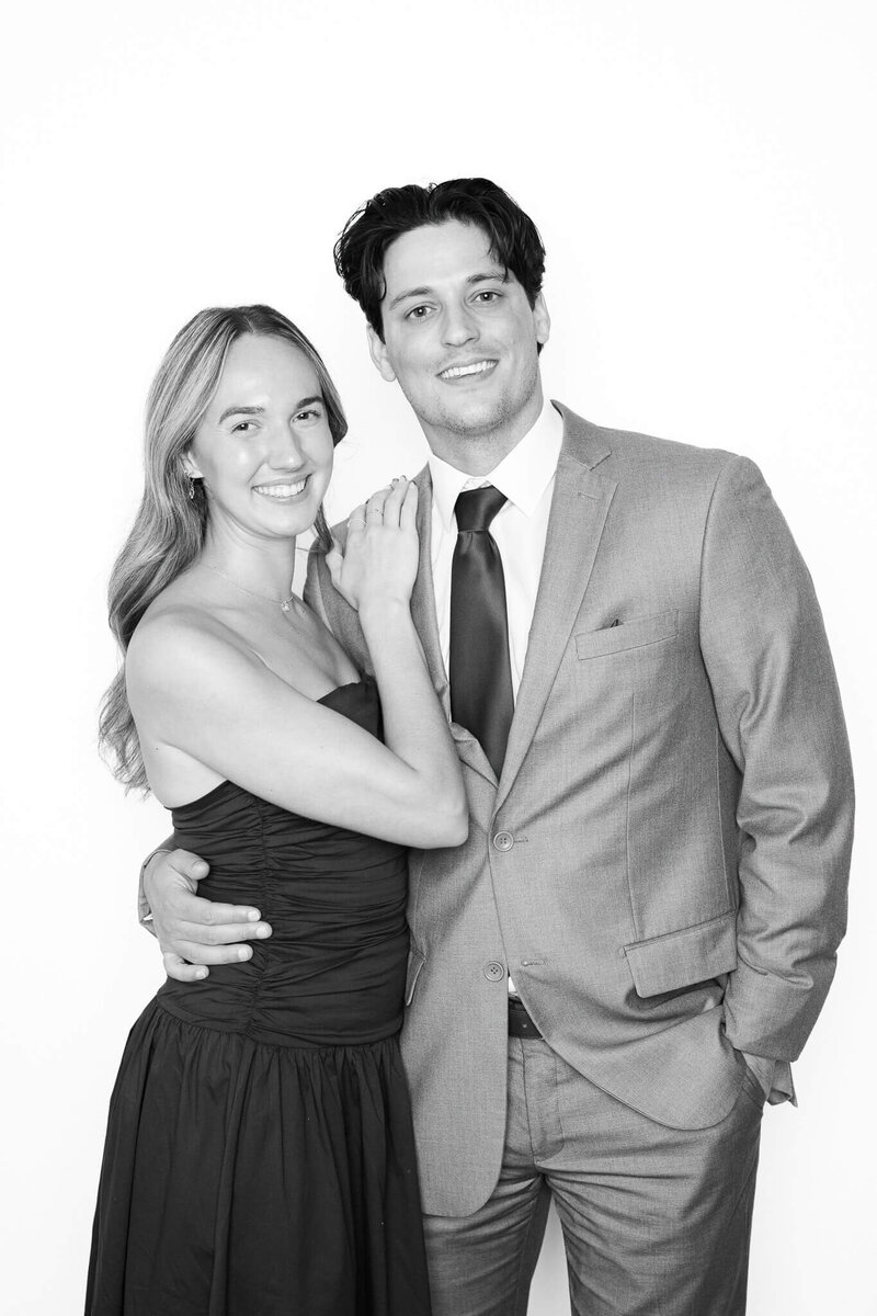 A smiling couple poses together in a classic black and white portrait by Monochrome Portraits, offering stylish photo booth rentals in Phoenix for elegant weddings and events.