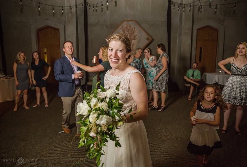 Bride about to throw her bouquet inside Gates Hall at Denver Botanic Gardens