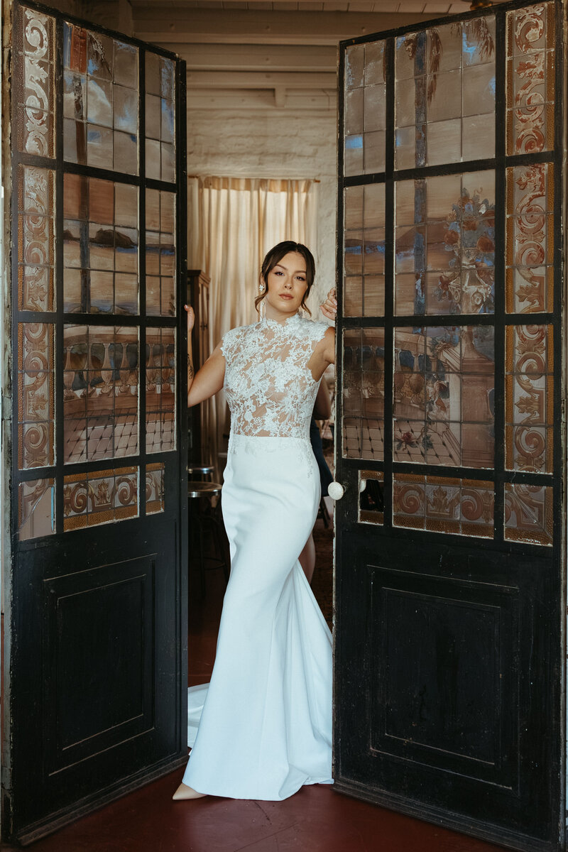 Portrait of modern bride in lace dress at race and religious wedding venue.