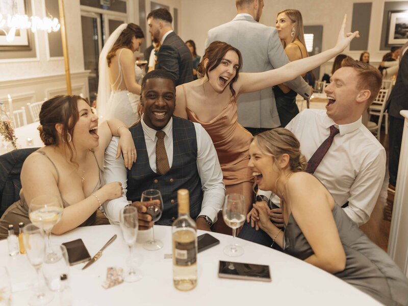 Bride's friends laughing at reception