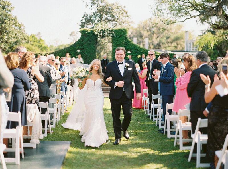 Bride and groom smile as they walk back down the aisle after taking their wedding vows