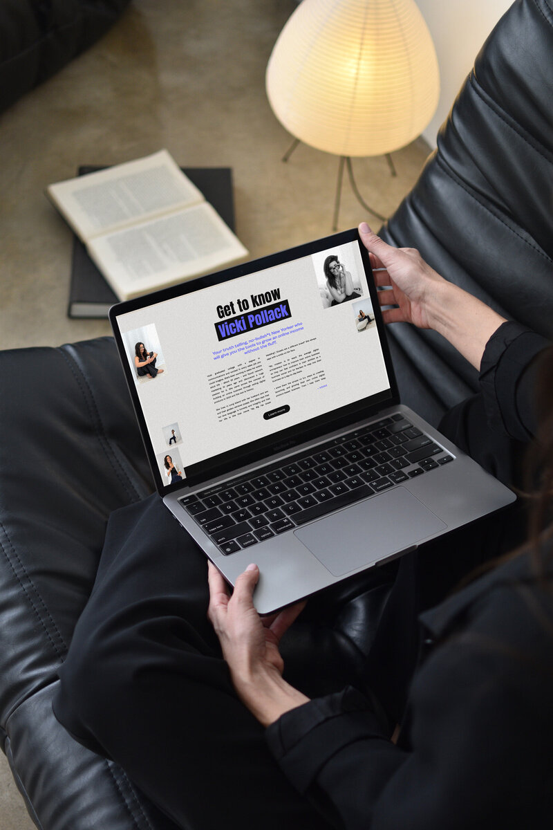 Woman holding laptop and sitting on black leather chair in New York