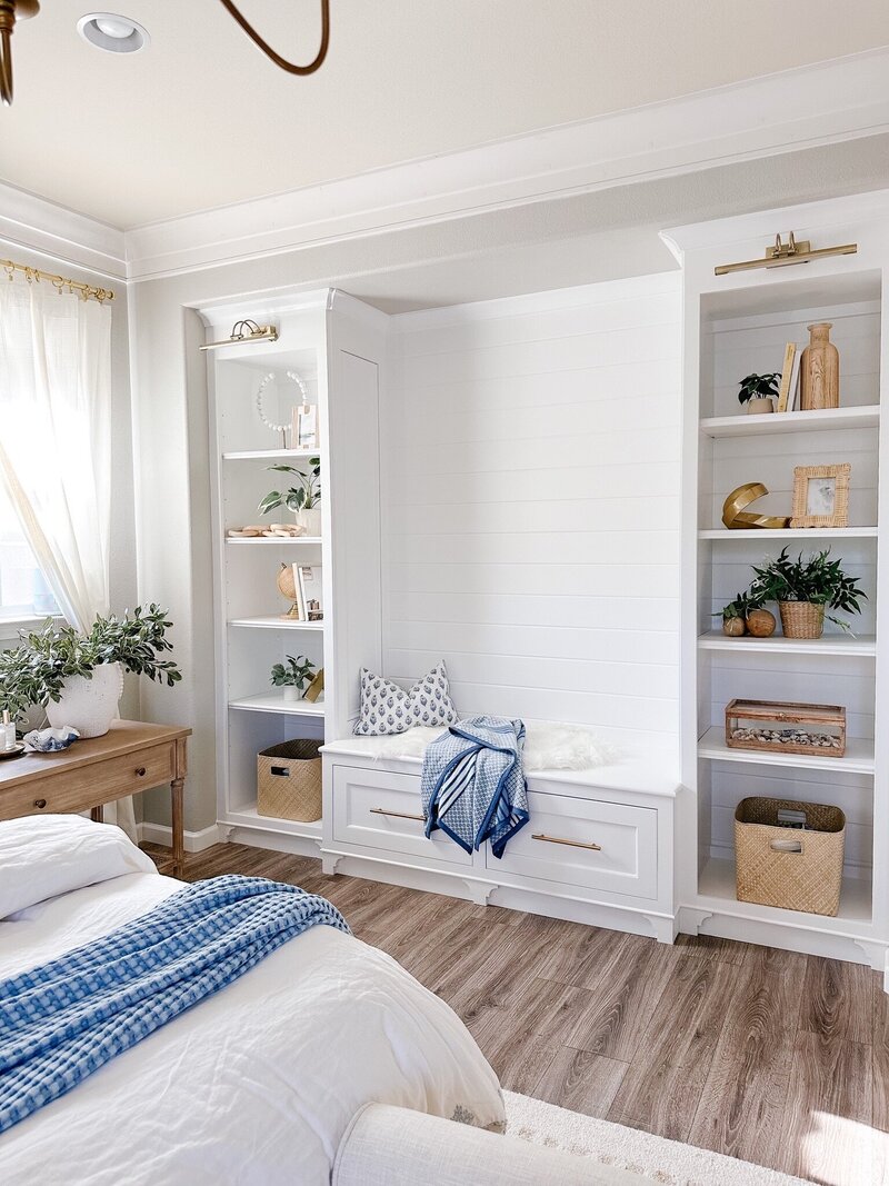 a reading nook with built in shelving in a bedroom