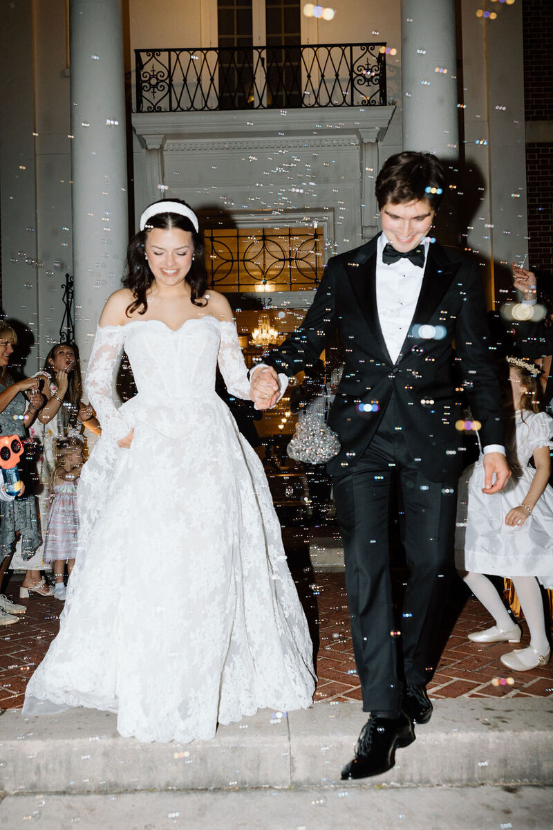 Couple walking through bubbles during wedding exit