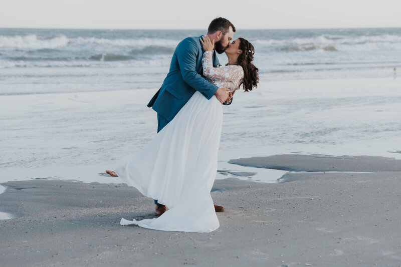 bride and groom kissing on beach