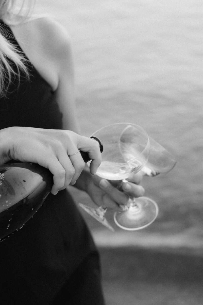 woman pouring wine into two glassed