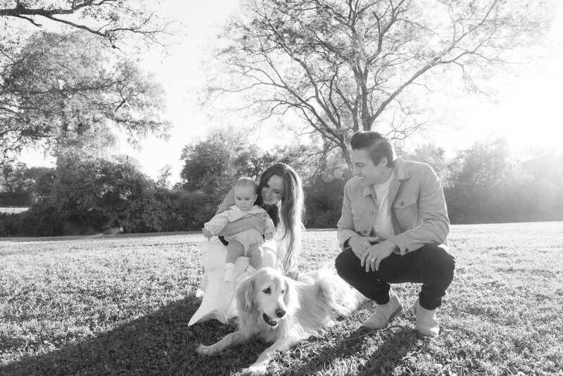 Black and white photo of family gathered around family dog during family photo session in Franklin, TN.