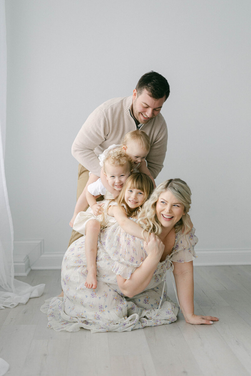 stacked family photo with mom on bottom and kids on top knoxville tennessee newborn photographer