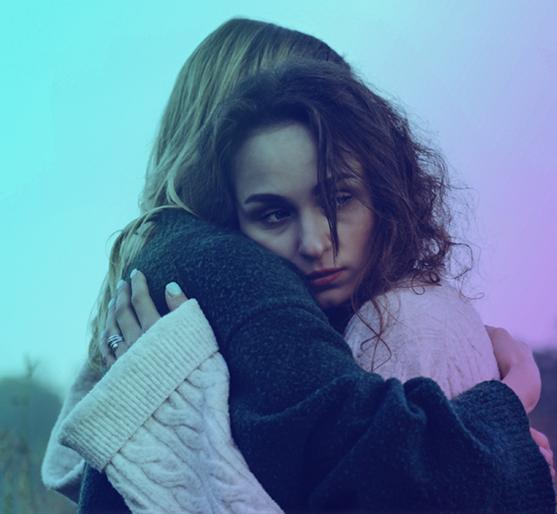 2 women hugging one blonde and one dark curly hair after domestic or sexual violence and abuse 